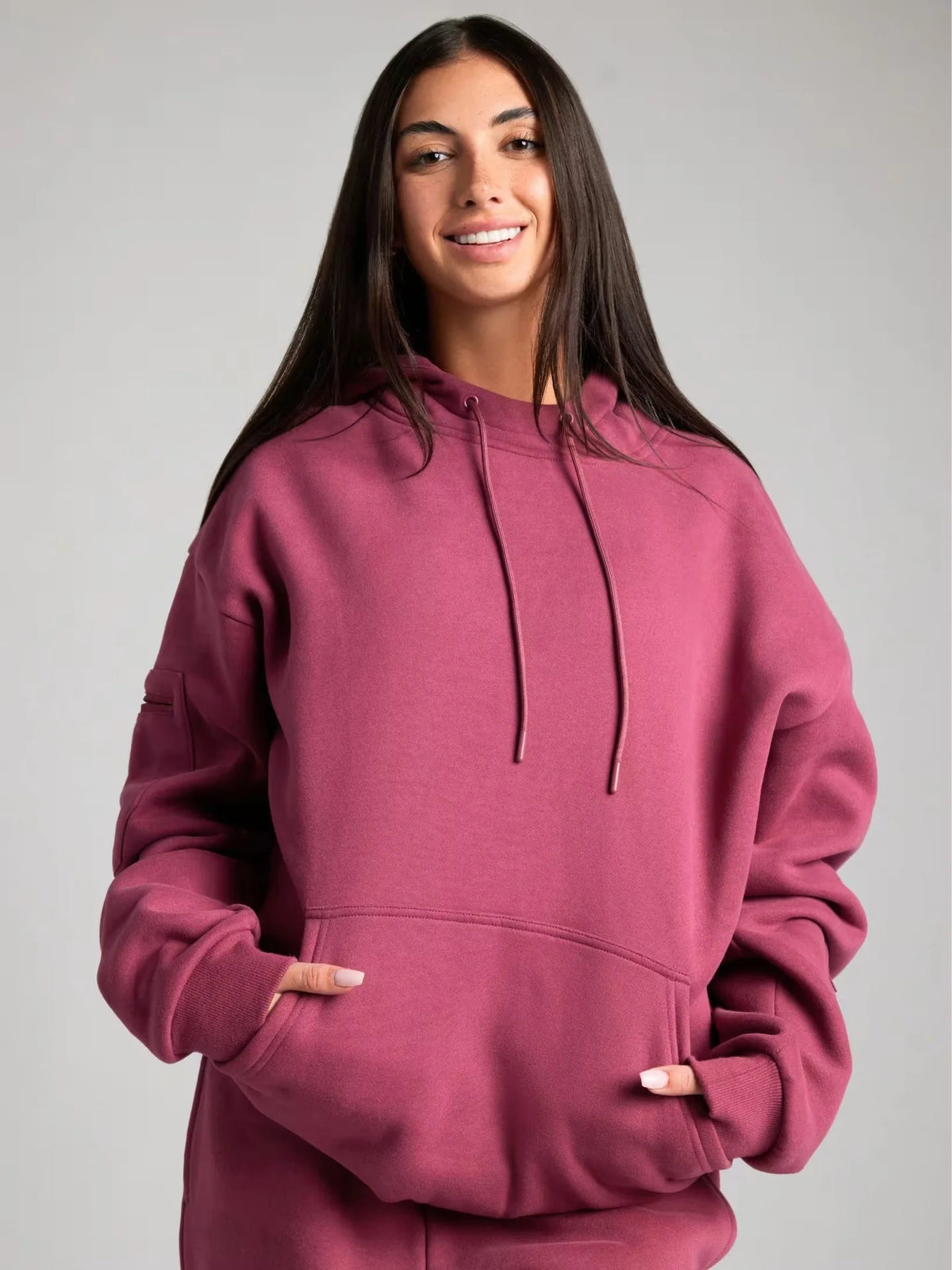 Person wearing a maroon hoodie against a plain background