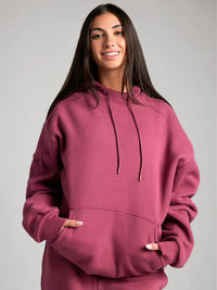 Person wearing a maroon hoodie against a plain background