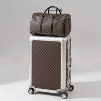The Monarch premium aluminum luggage set in Heritage Bronze, featuring a zipperless interlocking frame, curated and certified by AERIA Prestige.