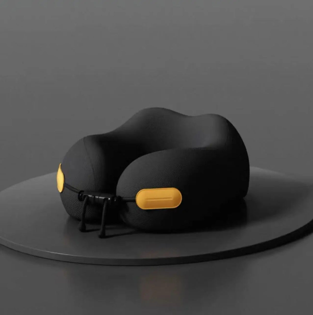 Black travel neck pillow with yellow accents on a dark gray background