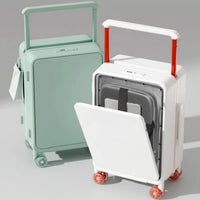 Two suitcases, one green and one white with red handles, on a wooden floor.