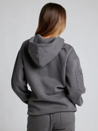 Person wearing a gray hoodie and pants on a plain background